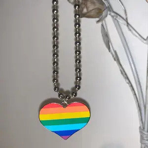 Fin halsband med ett hjärta som är regnbågsfärgad 