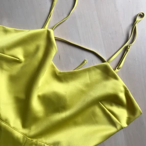 Gul byxdress med öppen rygg - En gul byxdress i gul. Öppen rygg och dragkedja därbak. Aldrig använd, st 36 
