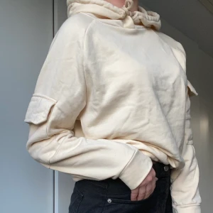 Hoodie - (FRI FRAKT) beige hoodie med fickor på armarna som en cool detalj. Köpt för något år sen men inte använd så mycket. Den är i stl XS, men ganska stor för storleken så skulle säga att den är lite oversized. Mjukt material inuti 