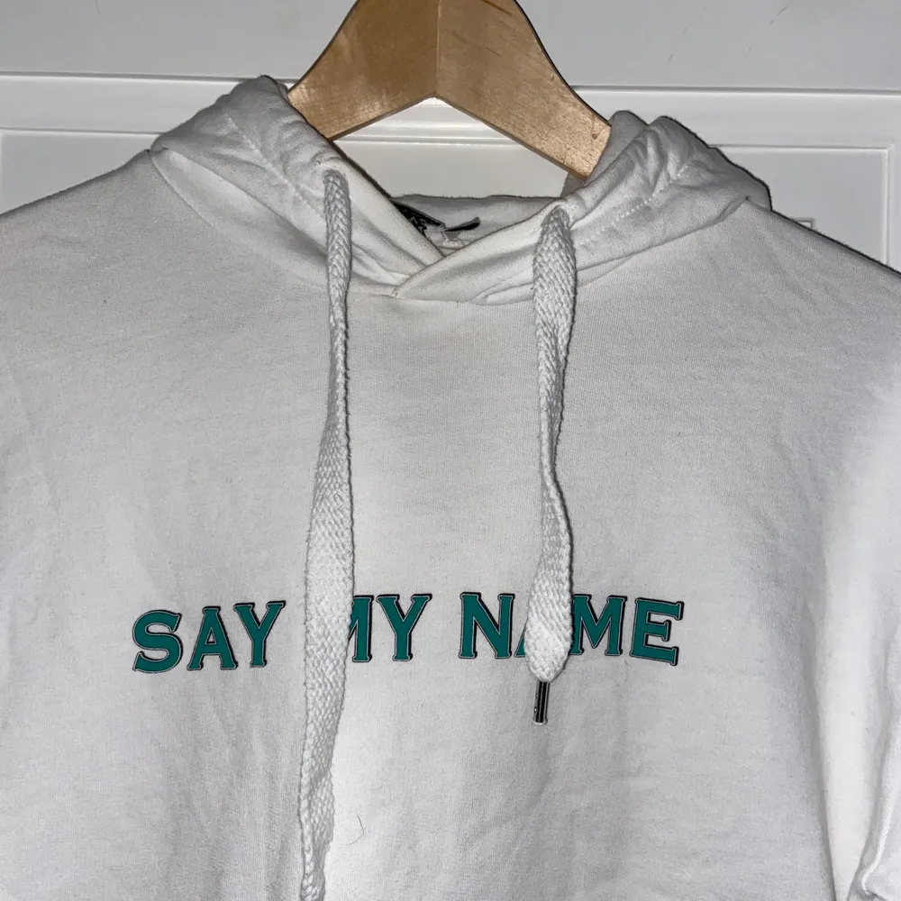 En vit lite tunnare hoodie från NAKD  med grön text där de står ”Say my name”. Den är i storlek S och skulle säga att den är normal i storleken. Så himla skön! Skriv för fler bilder<33. Hoodies.