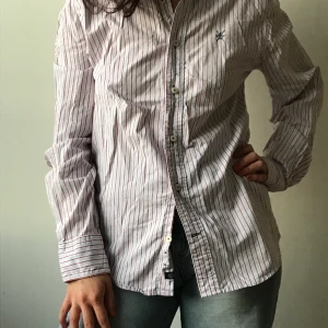 Randig sommarskjorta - Underbar randig sommarskjorta. Skön och sval i 100% bomull. Sitter fint avslappnat på mig som är S, men passar också större storlekar utan problem! Från East west. 