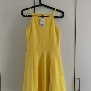 Sommarklänning  - En gul sommarklänning, helt oanvänd, storlek 40