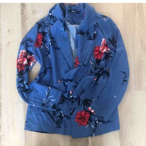 Blå blommig blazer kavaj Gina Tricot - Så snygg och perfekt nu i sommar. Blommig blazer med band i midjan. Strl 36. Från Gina tricot.