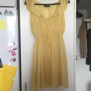 Klänning stl 36 - Gul sommarklänning. Gul underklänning med spagetti-straps och en genomskinlig gulprickig klänning över. ( klänningen under är avtagbar) 