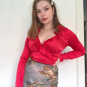 Röd wrap topp - Glansig röd wrap topp från Vero Moda. Super cool modell och färg. Väldigt sparsamt använd då den sitter dåligt på mig. Storlek S.