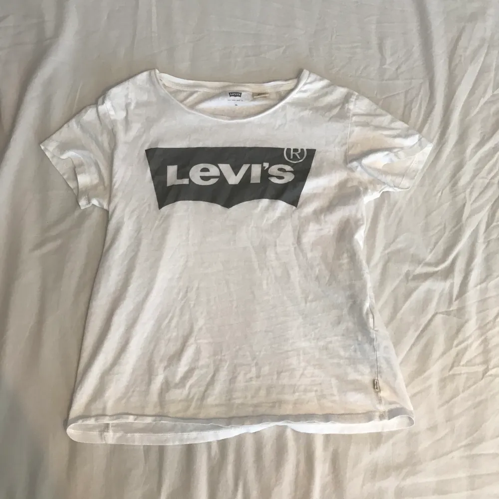 En vit t-shirt ifrån Levi’s med ett silvrigt/grått print, använt några gånger men utöver det är tröjan i gått skick! Nypris 299kr, du står för frakten🥰. T-shirts.