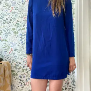 En härligt blå klänning. Snyggt att knyta ett band i midjan. Den är kort i modellen dock är jag 179cm lång. Skicket är okej därav priset.