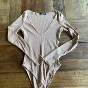 Body ifrån Boohoo - Jätte snygg ribbad beige body ifrån Boohoo som inte kommit till användning och är i fint skick 
