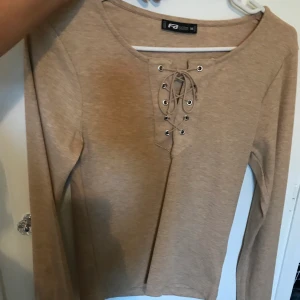 Topp med snörning  - Oanvänd tröja i storlek medium, passar small och medium