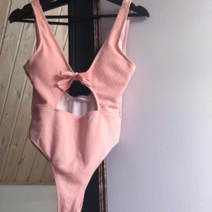 Rosa Baddräkt - Gullig ribbad rosa baddräkt från Born in Stockholm. Djup urringning och rygg. Inlägg i kuporna som går att ta ur. Priset är INKL FRAKT!🌸