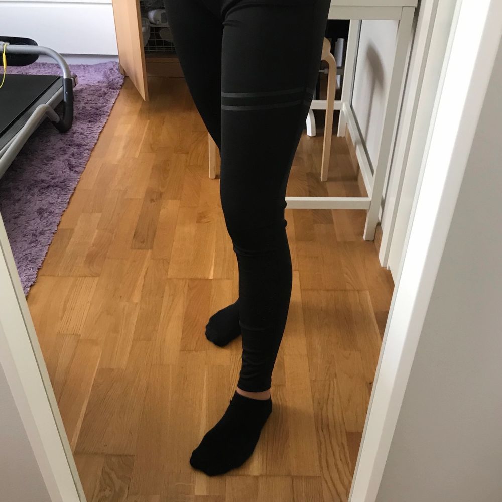 Svarta tränings tights med två svarta sträck över ena benet. Snygga och sköna, men kommer inte till användning.. Jeans & Byxor.
