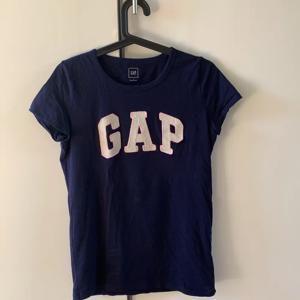 Super fin äkta Marinblå GAP T-shirt! Lite glittriga detaljer i texten GAP. Använd ca 3 gånger!💙 Köparen står för frakt!. T-shirts.