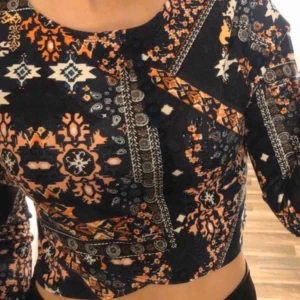 Croppad tröja - Croppad tröja med mönster. Knappt använd så den är som ny. Den är i storlek M men passar mig som är en S. Kom med bud