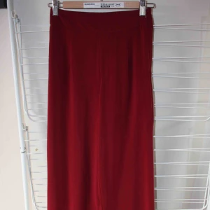  - Vinröda Adriana byxor från BIKBOK. Storlek XS. Endast använda en gång :) dom sitter sååå snyggt! Kommer dock inte till användning av mig. Såg att det var en reva längst vänstra benet på bredden (se bild 3) Frakt kostar 59kr