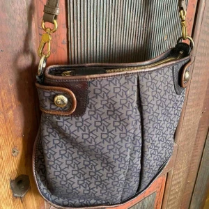  - DKNY väska med beige läderband från Marc Jacobs. Använd men jätte fint skick. Några fläckar i innertyget annars inga anmärkningar, Frakt står köparen för. Kan skicka mer bilder 💞🌙💓