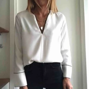  - En vit blus med svarta detaljer, använd 1-2 gånger. Köpt i våras. Passar perfekt till en kavaj eller svarta kostymbyxor. Köparen står för frakt