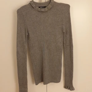 Rubbad grå tröja - Grå ribbad tröja. Frakt tillkommer. I nyskick. Sälja billigt då jag rensat garderoben innan flytt och vill bli av med kläder jag ej använder. 