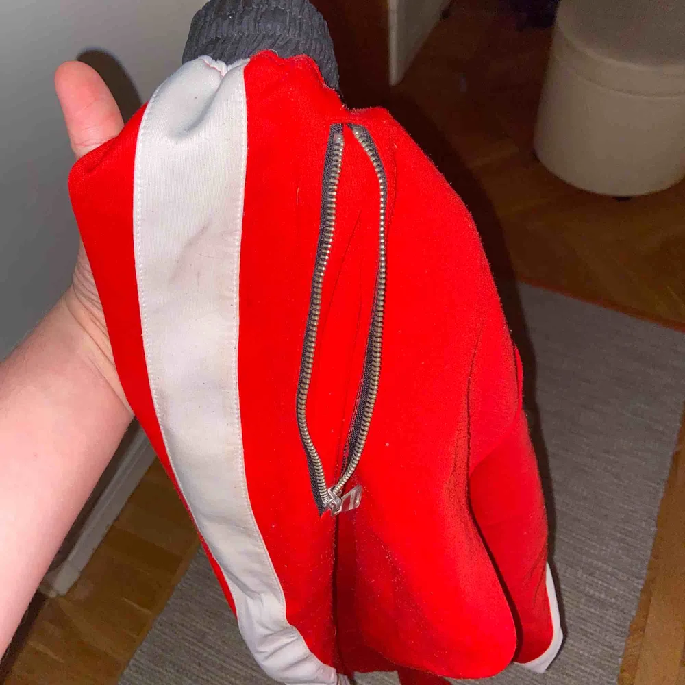 Skitfeta röda trackpants i storlek 32, har en slim-fit med dragkedjor längsmed anklarna. Perfekt för en skön och mysig outfit. . Jeans & Byxor.