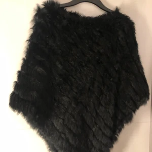 Svart päls poncho - En svart poncho i äkta päls, väldigt mysig o fin. Det är en one size som passar alla. Använd, dock fortfarande helt felfri.