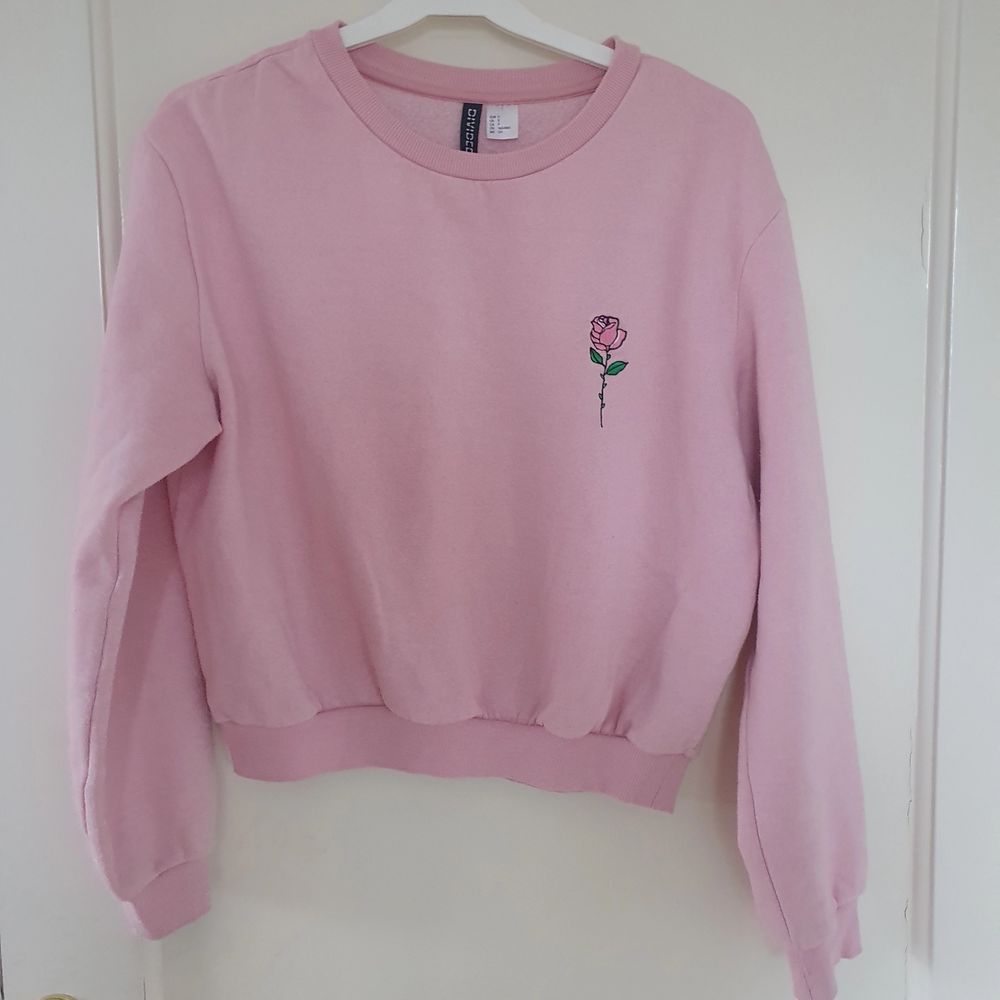 En jättegullig rosa tröja med en ros på🌹 Tröjan är köpt på H&M för något år sedan, den är använd en del men är i bra skick💓. Tröjor & Koftor.