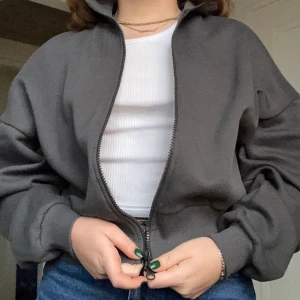 Zip Up Sweater - Jättefin mörkgrå zip up tröja i storlek S från Nelly! Kommer tyvärr inte till användning hos mig och använt den endast 1-2 ggr, och är därför i väldigt fint skick! Oversize fit. Nypris: 350kr Köparen står för frakt!