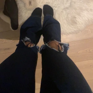 Lågmidjade jeans - Säljer dessa marinblå, lågmidjade utsvänga jeans med hål på knäna. Köpte dessa jeansen från bubbleroom för ett år sedan ungefär för ungefär 600kr. Använder de inte längre så därför säljer ja de💞