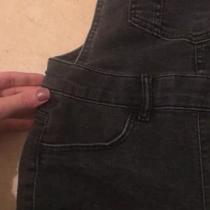 H&M hängselbyxa  - Jag säljer denna hängselbyxan med rivna detaljer i slutet av byxan! Den är i bra skick och priset kan diskuteras 💖 