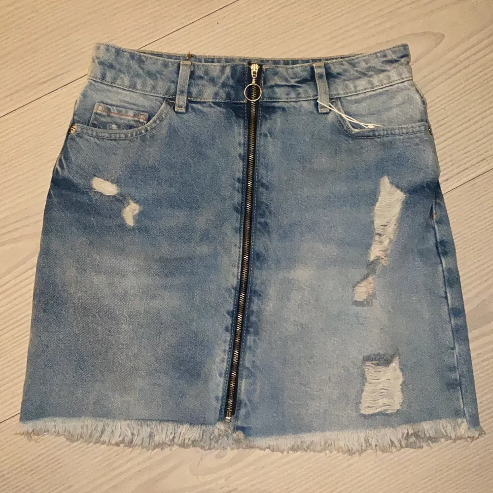 Ripped Jeans kjol från Zara med dragkedja längst hela framsidan, aldrig använda, köpt dom i Thailand därför är prislappen i thai valuta, original pris är c 350-400kr. Kjolar.