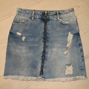 Zara jeans kjol - Ripped Jeans kjol från Zara med dragkedja längst hela framsidan, aldrig använda, köpt dom i Thailand därför är prislappen i thai valuta, original pris är c 350-400kr