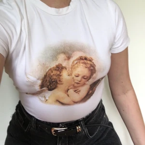 Änglar tshirt - Väldigt söt vit tshirt med ängel tryck, stretchig och bekväm. Sparsamt använd. Frakt ingår :)