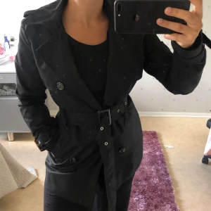 Kappa - Svart kappa köpt från Zalando, väldigt god kvalité, stilren, funkar med och utan bälte, storlek 34, säljer på grund av passar inte mig längre, använd endast ett fåtal gånger, inga tecken på användning. 