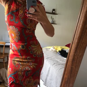 Mönstrad röd second hand klänning - Aldrig använd av mig då jag blev kär i den men aldrig kunnat stänga dragkedjan helt bak. Köpt på second hand butik. 