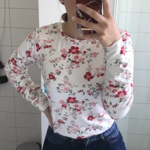 Vit blommig tröja - Jättemysig vit långärmad tröja i mjukt material, knappt använd i storlek M. Säljer pga att jag inte använder tröjan.