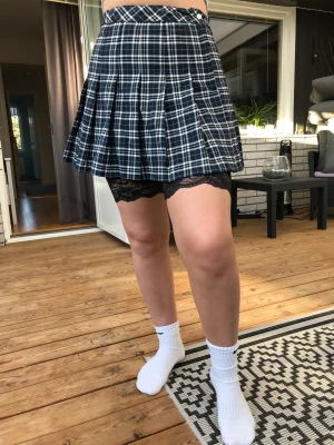 Rutig marinblå kjol - Marinblå Kjol från HM. Säljer pga att jag beställde den och den var för liten. Använd endast en gång. Har cykelbyxor under eftersom att den är för liten. 