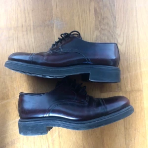 Kostymskor från Bolton, strl 40 - Bruna blanka kostymskor från Bolton , strl 40. Bekväma att bära, köpta second hand, men knappt använda av mig så i mycket gott skick. Köparen står för frakt!