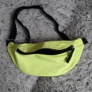 Veromoda magväska  - Neongul magväska från Veromoda. Fint skick, dock en missfärgning på baksidan (se bild), inget som syns vid användning. 
