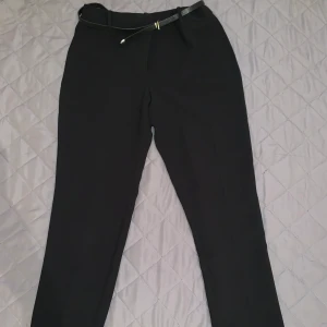 Kostymbyxor Dam Mango, Str 36-38 - Stilrena och snygga kostymbyxor från Mango som har använts max 5 gånger, säljer p.g.a. att byxan än något stor i storleken. Den passar perfekt för dig som är mellan storlek 36-38.
