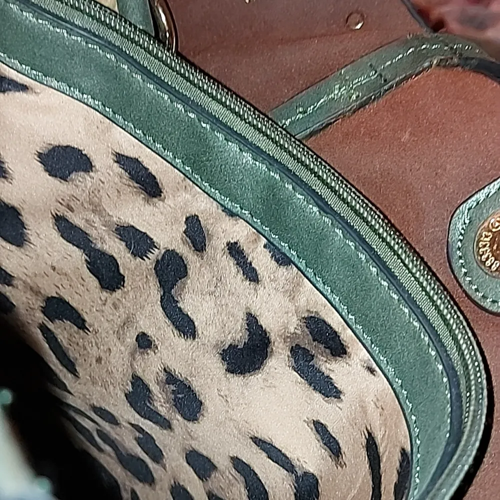 En stor handväska med mycket detaljer såsom nitar, diamanter osv. Den är aldrig använd där med det exemplariska skicket. Insidan har många fack och har leopard mönster inuti.. Väskor.