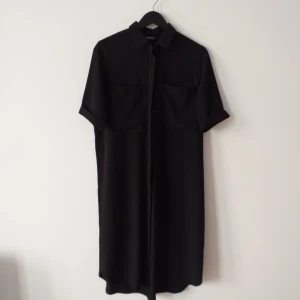 Skjortklänning/kavaj S/M/L - Skjortklänning i gott skick från Monki. Använd fåtal gånger. Kan även användas som kavaj viket jag gjorde :) slits där fram, alltså att knapparna inte går hela vägen ner. Sfår storlek S men jag som har L kan ha den.