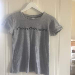 Grå T-shirt från Calvin Klein i storlek XS, i fint skick 