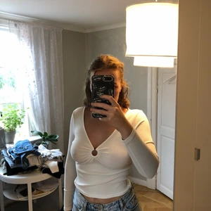 Vit långärmad topp - Jättefin långärmad topp från ASOS med brunmelerad plastring mellan brösten. Knappt använd. Frakt ingår ej.