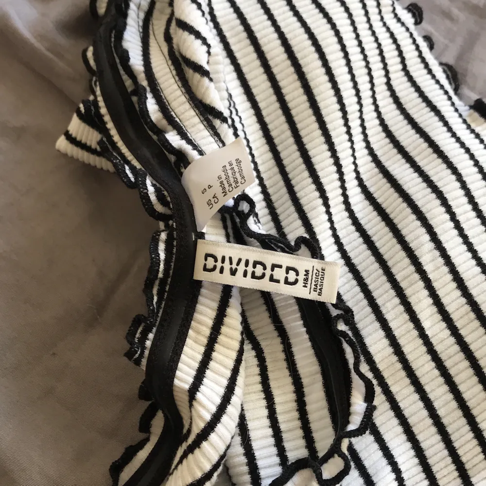 H&M långärmad tröja med svarta kryllar på kanterna, svart o vit randi. Neuletakit & Villapaidat.