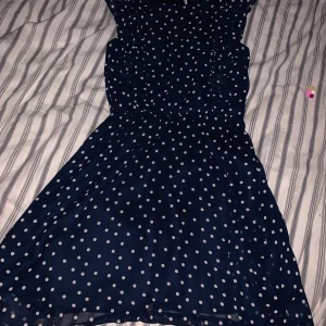 Klänning storlek 152 - Det är en Mörk blå klänning med vita prickar och volanger