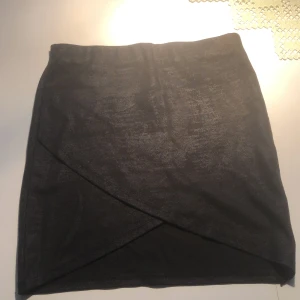 Kjol från Ginatticot i strl S - En snedskuren kjol med lite skimmer på. Knappt använd så i mycket bra skick.