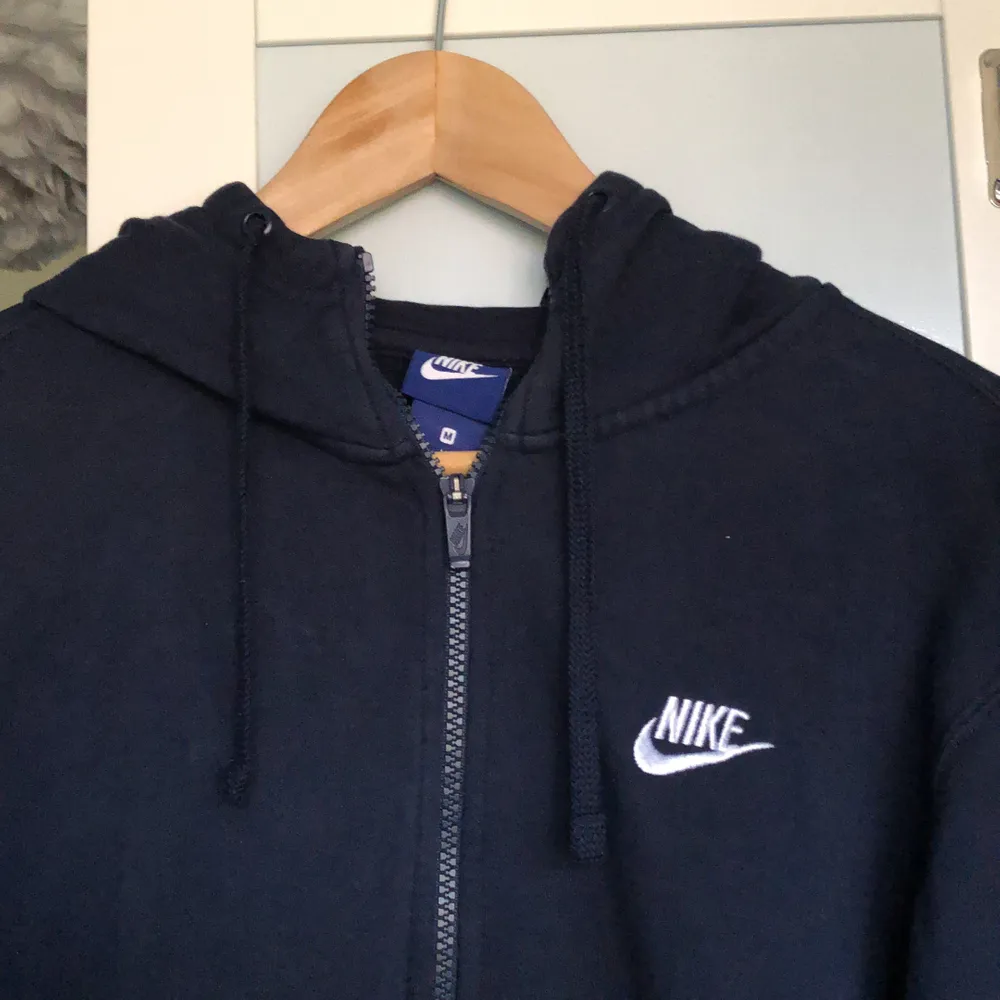 Mörkblå Nike hoodie med dragkedja och märket på sidan. Köpt i nikeaffären i Spanien för några år sen och säljer för jag behöver pengar. Jättebra kvalitet fortfarande och har inga fläckar alls. Varm och skön till vinter. Hoodies.