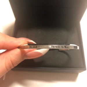 Daniel Wellington armband - Stelt silver armband från Daniel Wellington med loggan på. Storlek S i fint skick, lite ”repig” som knappt är synligt. Original lådan medföljer! 