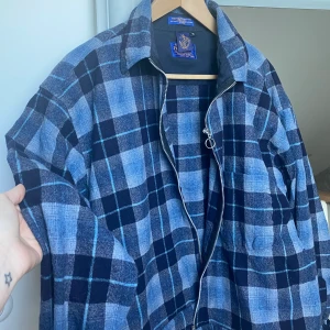 Rutig Beyond Retro jacka - Säljer denna supersnygga Yllejacka! Köpt på Behind regi i Stockholm för ca 2 år sedan, knappt använd sedan dess. Jackan är i stl M och sitter lite oversized på ett väldigt snyggt sätt på mig som har S annars! Kan bjuda på frakten vid smidig affär!🥰