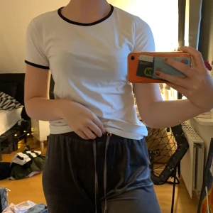 Vit t-shirt  - Fin vit t-shirt me svarta sömar vid ärmarna och halsen. Använd lite grann, bra skick. Inte så figursydd
