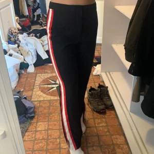 Kostymbyxor - Vida kostymbyxor från Ivyrevel, svarta med röda o vita streck på sidorna. Större slits där nere, säljer pga för stora! Använd Max 1 gång // Frakt tillkommer💗