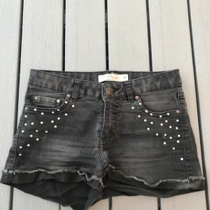 Shorts i storlek 158 - Svarta shorts med nitar framtill i storlek 158 ungefär som en XS. Jag minns inte var de är ifrån. (Frakten ingår i priset)